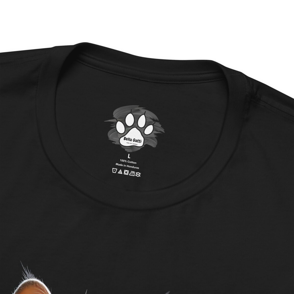 14386252378622637031_2048.jpeg Black t-shirt collar label with Bella Gatti paw print logo, size L, 100% Cotton, Made in Honduras.