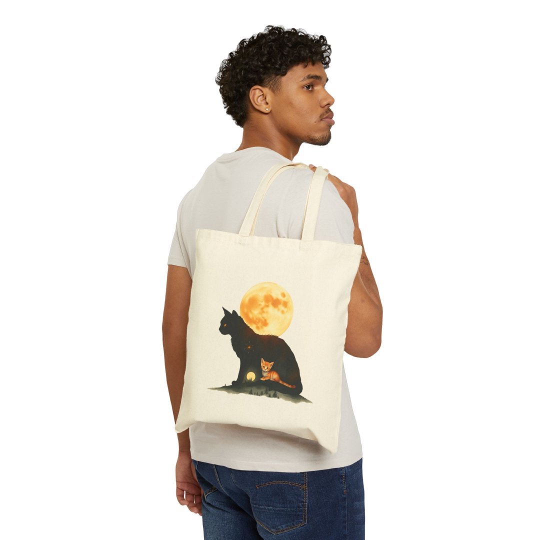 1610792643975070558_2048.jpeg Man carrying a tote bag with a cat and moon design.