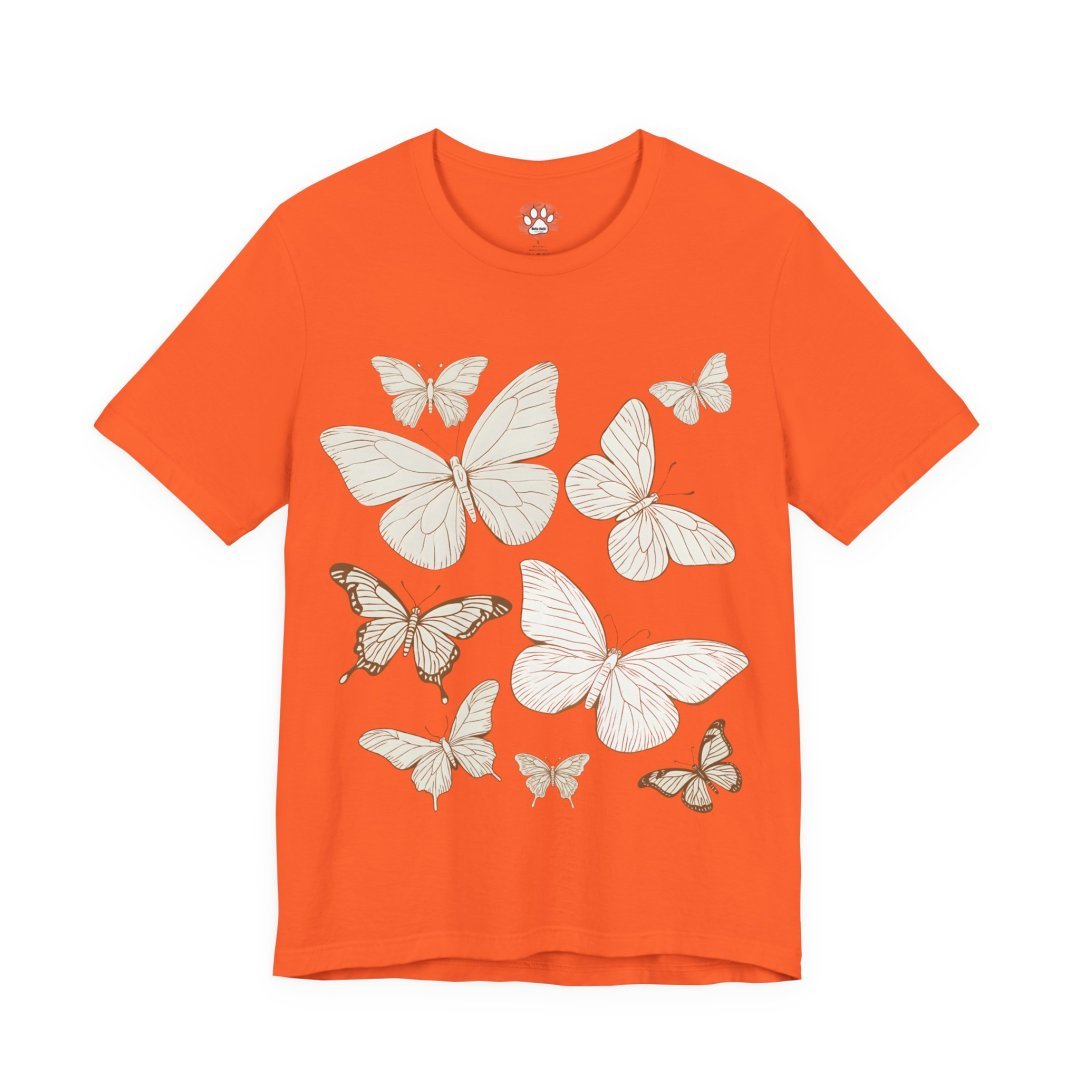 16472371467591405134_2048.jpeg Orange t-shirt with white butterfly illustrations.