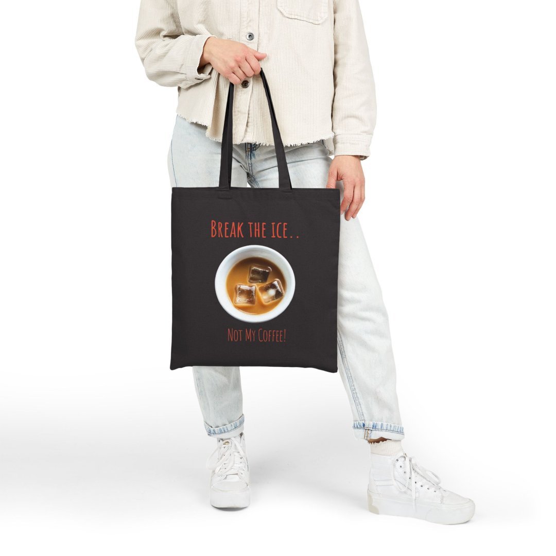 6204819925221982054_2048.jpeg Person holding a black tote bag with iced coffee design.