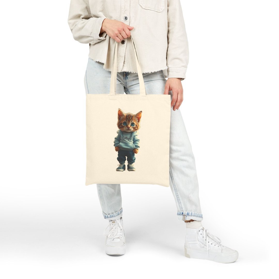 9556203345960980738_2048.jpeg Person holding a tote bag with a cute cat in a hoodie design.