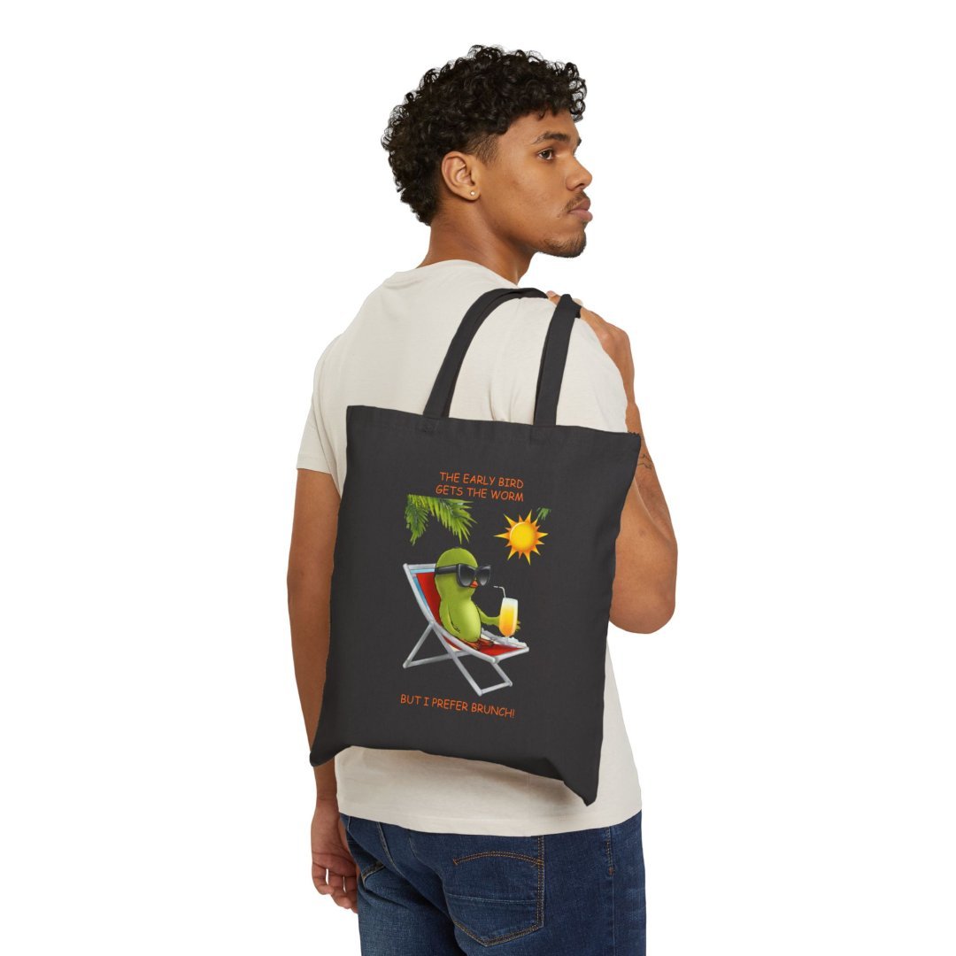 10112707199892491813_2048.jpeg Man carrying a tote bag with a bird lounging on a chair design.