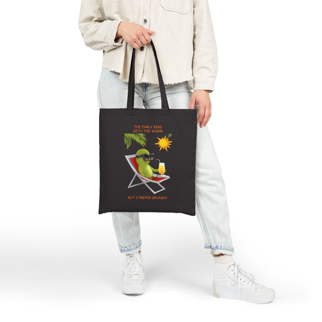 10433537914684459033_2048.jpeg Person holding a black tote bag with a brunch-themed design.
