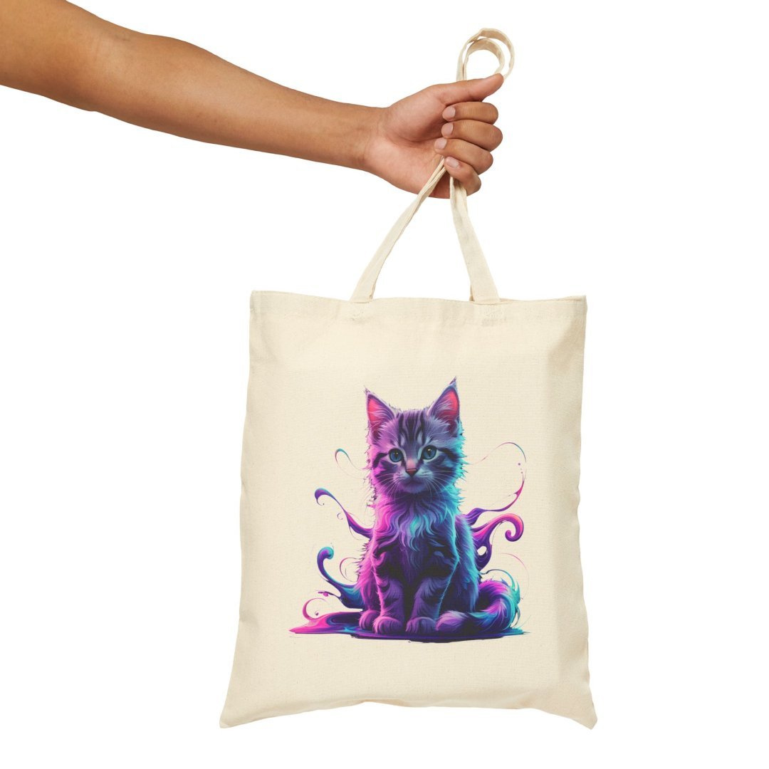 11764007815690573317_2048.jpeg Hand holding a tote bag with a colorful cat design.