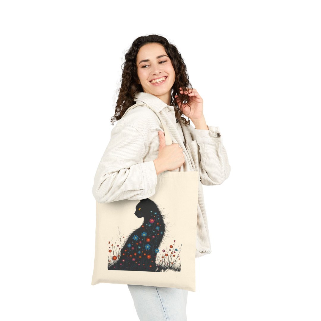 15281893213863065684_2048.jpeg Woman smiling and carrying a tote bag with a floral cat design.