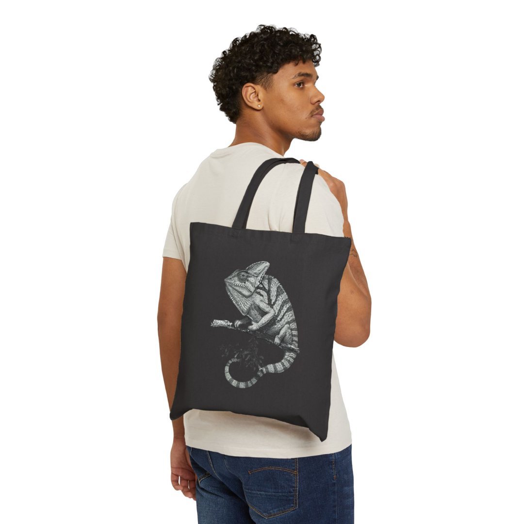 16160971038769522239_2048.jpeg Man carrying a black tote bag with a chameleon design.