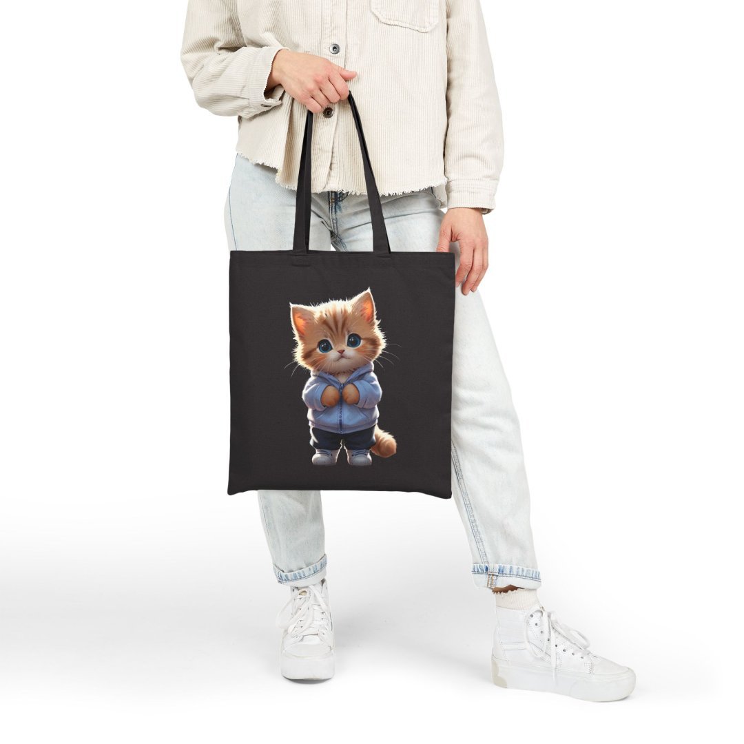 16405814981329761309_2048.jpeg Person holding a black tote bag with a cute kitten in a blue sweater design.