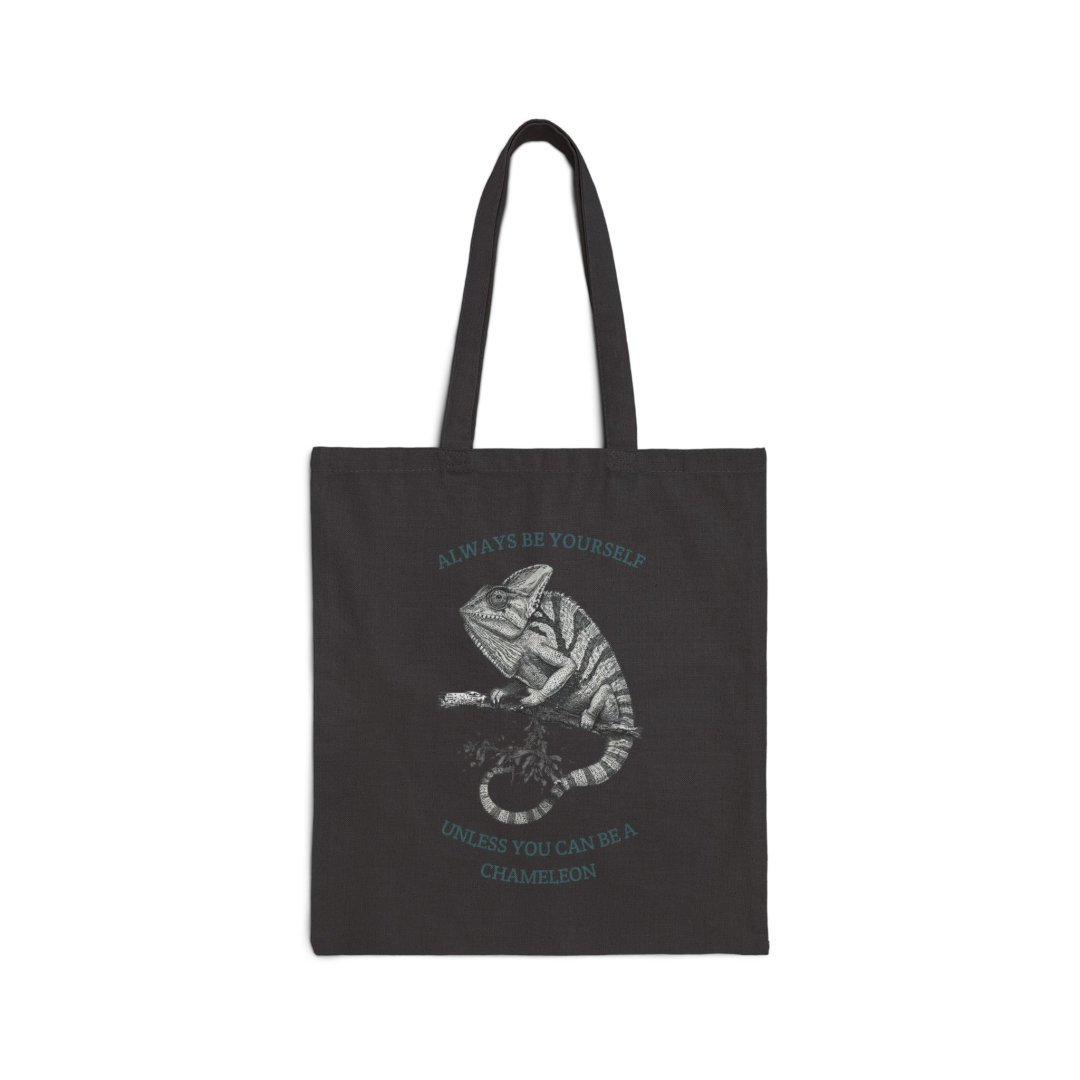 16557649662825341573_2048-1.jpeg Black tote bag with a chameleon illustration and motivational text.