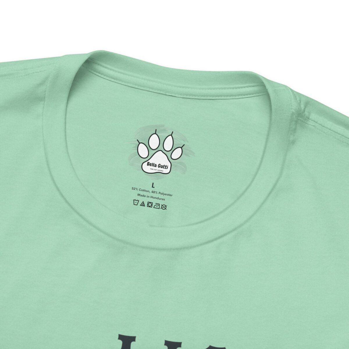 16926190324730913558_2048.jpeg Mint green t-shirt with a printed neck tag featuring a cat paw print, "Bella Gatti" brand, size L, and fabric details.