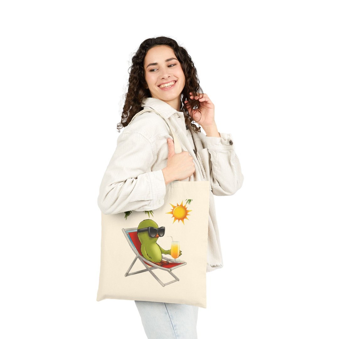 17597007563227746532_2048.jpeg Woman carrying a tote bag with a cartoon avocado on a beach chair.
