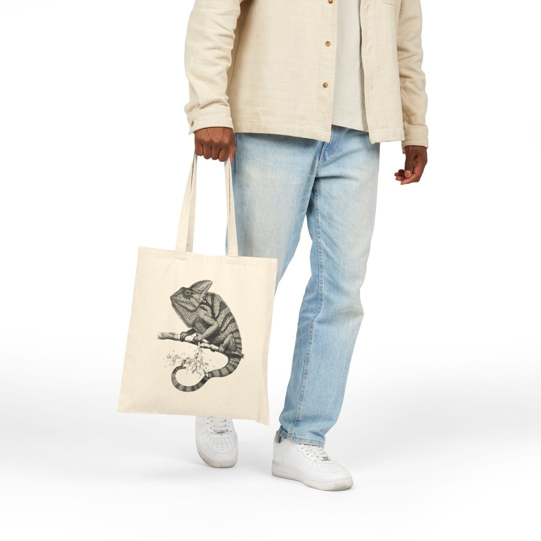 1942613512906037412_2048.jpeg Person holding a tote bag with a chameleon design.