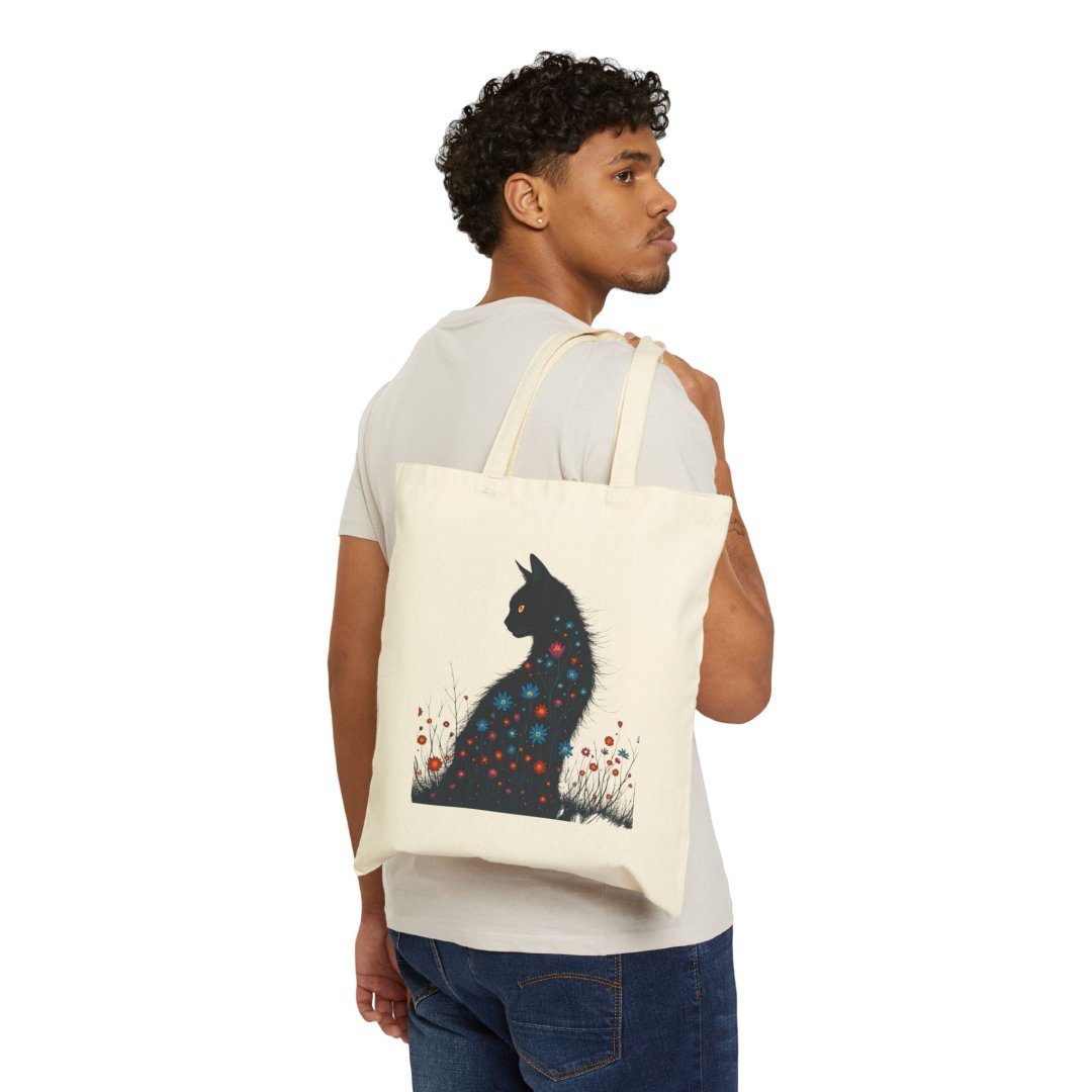 195421648782082905_2048.jpeg Man carrying a tote bag with a cat silhouette design.