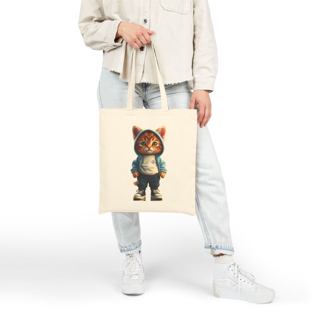 2661346748503139544_2048.jpeg Person holding a tote bag with a cat in a hoodie design.