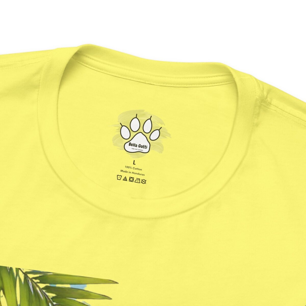 2679860433578129855_2048.jpeg Yellow t-shirt with a 'Bella Gatti' cat paw print label and a partial palm leaf design.