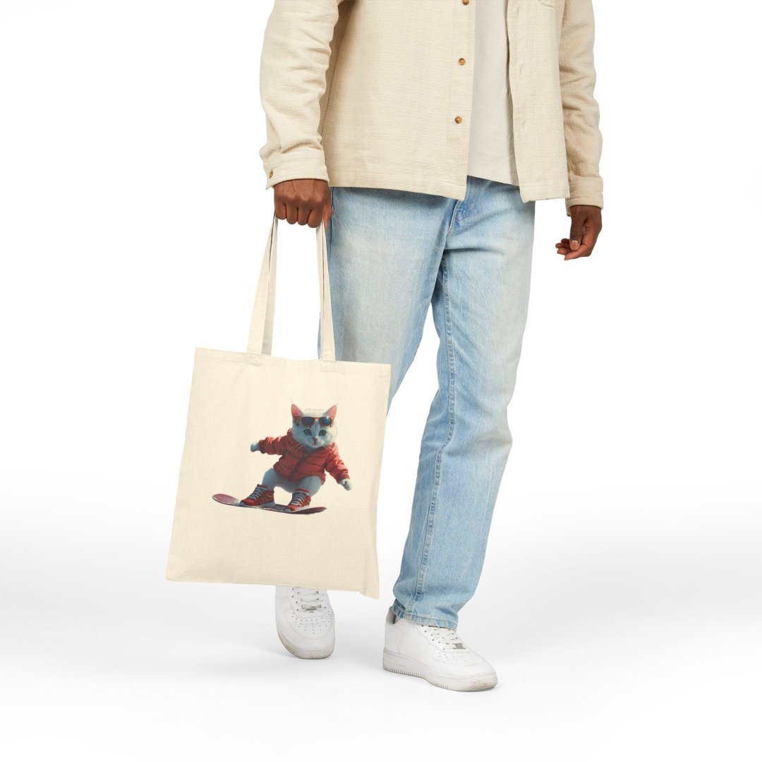 7489017475779907063_2048.jpeg Person holding a tote bag with a cat on a skateboard design.