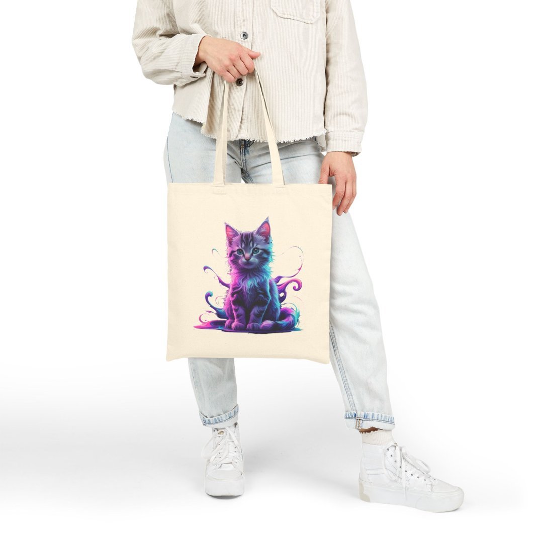 9015627778349153879_2048.jpeg Person holding a tote bag with a colorful cat design.