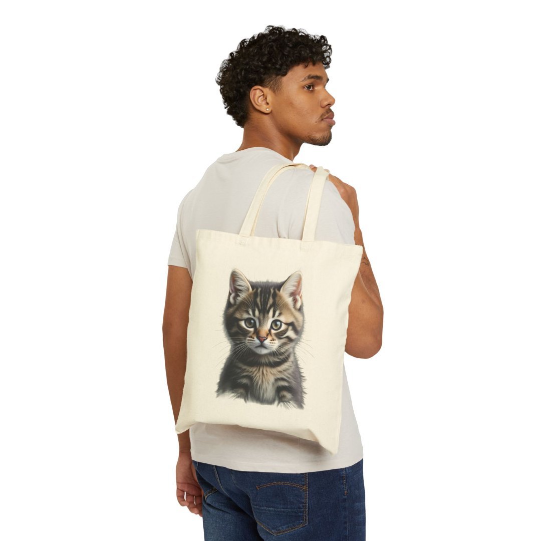 9669604758286185476_2048.jpeg Man carrying a tote bag with a cat illustration.