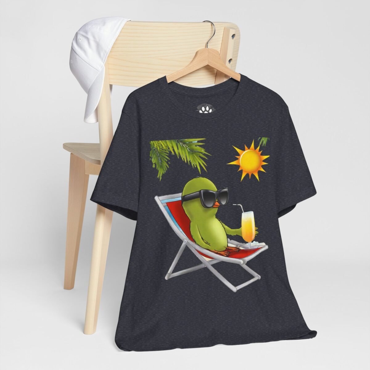9838132830351290323_2048.jpeg Dark grey t-shirt featuring a green cartoon bird in sunglasses relaxing on a beach chair with a drink under a palm and sun.
